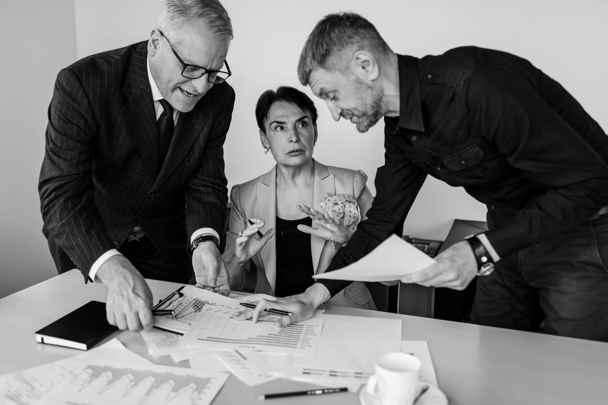 Three colleagues reviewing documents at a table