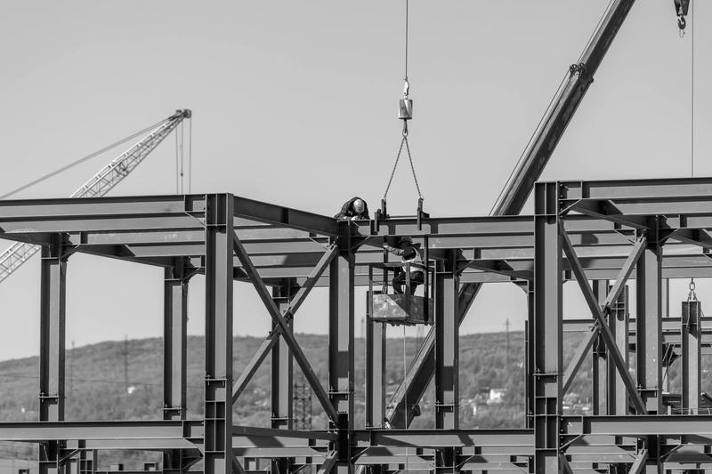 A crane lifting steel onto a building frame