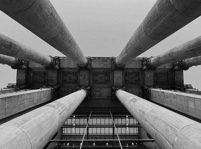 Looking up between the stone columns of a portico